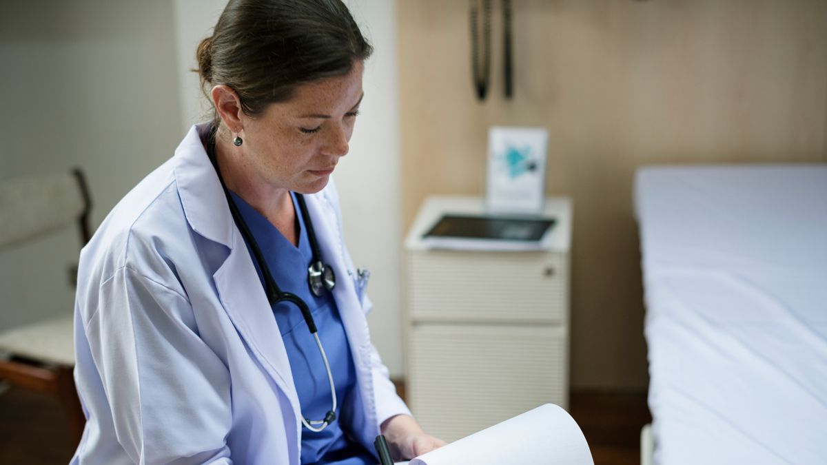 A nurse reading documentation to help with training